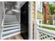 Bright entryway with wood-look flooring, stairs with blue trim, and a modern black front door at 3019 Camden Way, Alpharetta, GA 30005