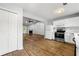 Modern kitchen flowing into the living room with white cabinets, stainless steel appliances, and vinyl wood floors at 3019 Camden Way, Alpharetta, GA 30005