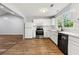 Bright kitchen featuring white cabinets, modern stainless-steel appliances, and hardwood flooring at 3019 Camden Way, Alpharetta, GA 30005