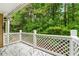 Inviting covered porch with white railing, overlooking a lush wooded landscape at 3019 Camden Way, Alpharetta, GA 30005