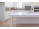 Kitchen island with white countertop, cabinets, sink, and backsplash at 5623 Meadowstone Walk, Kennesaw, GA 30152