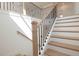 Bright staircase featuring wooden treads, white risers, and a black iron railing at 5623 Meadowstone Walk, Kennesaw, GA 30152