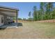 Large, grassy backyard featuring a covered patio and sturdy wooden fence, ideal for privacy at 707 Ralph Still Rd, Dacula, GA 30019
