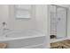 Bright bathroom featuring a soaking tub and a glass-enclosed shower with neutral colored walls and flooring at 707 Ralph Still Rd, Dacula, GA 30019