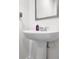Pedestal sink in a bathroom with a large framed mirror and natural colored walls at 707 Ralph Still Rd, Dacula, GA 30019