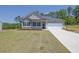 Charming single-story home featuring a two-car garage, gray siding, and a well-manicured front lawn at 707 Ralph Still Rd, Dacula, GA 30019