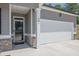 Close-up of the front entrance and garage, highlighting the gray siding and brick accents of the home at 707 Ralph Still Rd, Dacula, GA 30019