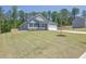 Well-maintained single-story home with gray siding, a two-car garage, and a lush, green front yard at 707 Ralph Still Rd, Dacula, GA 30019