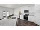 Bright kitchen boasts granite counters, stainless steel appliances, and dark wood floors at 707 Ralph Still Rd, Dacula, GA 30019