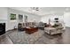 Spacious living room featuring a fireplace, dark wood floors, and a large sectional sofa for comfortable seating at 707 Ralph Still Rd, Dacula, GA 30019