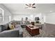 Open-concept living space with a large gray sectional sofa, dark wood floors, and bright, natural light at 707 Ralph Still Rd, Dacula, GA 30019
