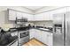 Modern kitchen featuring white cabinets, stainless steel appliances, and black countertops at 211 Colonial Homes Nw Dr # 1105, Atlanta, GA 30309