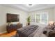 Staged main bedroom featuring a large window, natural light, and hardwood floors at 211 Colonial Homes Nw Dr # 1105, Atlanta, GA 30309