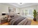 Staged main bedroom featuring a large window, natural light, and hardwood floors at 211 Colonial Homes Nw Dr # 1105, Atlanta, GA 30309