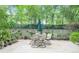 A backyard patio with a seating area is shaded by tall leafy trees at 211 Colonial Homes Nw Dr # 1105, Atlanta, GA 30309