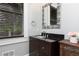 Bathroom featuring a black granite vanity top, decorative mirror, and a window with blinds at 610 Valley Green Trce, Marietta, GA 30068