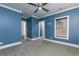 Airy bedroom featuring blue walls, white trim, large window, and ceiling fan at 610 Valley Green Trce, Marietta, GA 30068