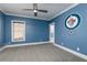Airy bedroom featuring blue walls, white trim, large window, ceiling fan and team logo at 610 Valley Green Trce, Marietta, GA 30068