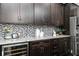 Close-up of kitchen features granite countertops, wine cooler, and mosaic backsplash at 610 Valley Green Trce, Marietta, GA 30068