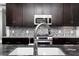 The kitchen has granite countertops, dark wood cabinets, and stainless steel appliances for a contemporary design at 610 Valley Green Trce, Marietta, GA 30068