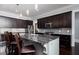 The kitchen has an island with seating, stainless appliances, and rich dark wood cabinets with a mosaic backsplash at 610 Valley Green Trce, Marietta, GA 30068