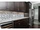 Modern kitchen featuring dark wood cabinets, granite countertops, and stainless steel appliances at 610 Valley Green Trce, Marietta, GA 30068