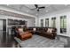 Open-concept living room featuring a large leather sectional, dark hardwood floors, and stylish ceiling design at 610 Valley Green Trce, Marietta, GA 30068