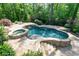 Resort-style pool and spa surrounded by stone patio and lush landscaping, perfect for relaxation at 610 Valley Green Trce, Marietta, GA 30068