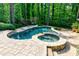 An inviting backyard pool and spa combination surrounded by lush landscaping and stone patio at 610 Valley Green Trce, Marietta, GA 30068