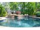 Tranquil pool area with cascading waterfalls, stone accents, and mature trees providing privacy at 610 Valley Green Trce, Marietta, GA 30068