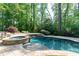 Inviting pool and spa area surrounded by stone paving and mature trees, offering a private oasis at 610 Valley Green Trce, Marietta, GA 30068