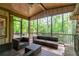 Inviting screened-in porch featuring a stone fireplace and outdoor seating overlooking lush greenery at 610 Valley Green Trce, Marietta, GA 30068