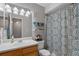 Traditional bathroom featuring a vanity with a white countertop, wooden cabinets, and patterned shower curtain at 3440 Essex Ave # 103, Atlanta, GA 30339
