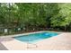 Swimming pool surrounded by a stone patio, trees, and an iron fence at 3440 Essex Ave # 103, Atlanta, GA 30339