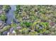 A high aerial view shows home nestled amongst green trees, adjacent to lake at 443 Lakeshore Dr, Berkeley Lake, GA 30096