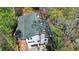 Aerial view of a home, highlighting its roof and location, surrounded by lush trees and a driveway at 443 Lakeshore Dr, Berkeley Lake, GA 30096