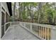 Large back deck with white railings surrounded by trees at 443 Lakeshore Dr, Berkeley Lake, GA 30096