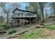 Backyard features a multi-level deck, a hammock, and a small creek surrounded by lush greenery at 443 Lakeshore Dr, Berkeley Lake, GA 30096
