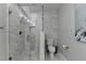 Modern bathroom featuring marble tile, a glass-enclosed shower, and contemporary fixtures at 443 Lakeshore Dr, Berkeley Lake, GA 30096