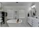 Bright bathroom featuring a freestanding tub, white shiplap walls, and black and white patterned tile flooring at 443 Lakeshore Dr, Berkeley Lake, GA 30096