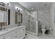 Modern bathroom showcasing double sinks, rustic mirrors, shower with glass door, and gray marble tiling at 443 Lakeshore Dr, Berkeley Lake, GA 30096