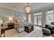 This gorgeous bedroom features a chandelier, neutral colors, and natural light from a sliding glass door at 443 Lakeshore Dr, Berkeley Lake, GA 30096