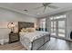 Primary bedroom featuring a king bed, ceiling fan, and access to the private outdoor deck at 443 Lakeshore Dr, Berkeley Lake, GA 30096