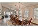 Dining room with rustic wood table, modern lighting, and an adjacent sitting area at 443 Lakeshore Dr, Berkeley Lake, GA 30096