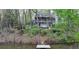The home's many levels make it an eye-catching feature, surrounded by green trees and the pond at 443 Lakeshore Dr, Berkeley Lake, GA 30096