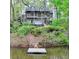 Charming two-story home with a dock on the lake, surrounded by lush greenery at 443 Lakeshore Dr, Berkeley Lake, GA 30096