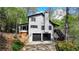Well-maintained two-story home with a black garage door, featuring a basketball hoop and lush landscaping at 443 Lakeshore Dr, Berkeley Lake, GA 30096