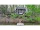 Charming two-story home nestled by a serene pond and a private dock, surrounded by lush trees at 443 Lakeshore Dr, Berkeley Lake, GA 30096