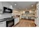 Bright kitchen with white cabinets, dark countertops, stainless steel appliances, and open dining area at 443 Lakeshore Dr, Berkeley Lake, GA 30096
