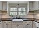The kitchen features a farmhouse sink, subway tile backsplash, and white cabinets at 443 Lakeshore Dr, Berkeley Lake, GA 30096